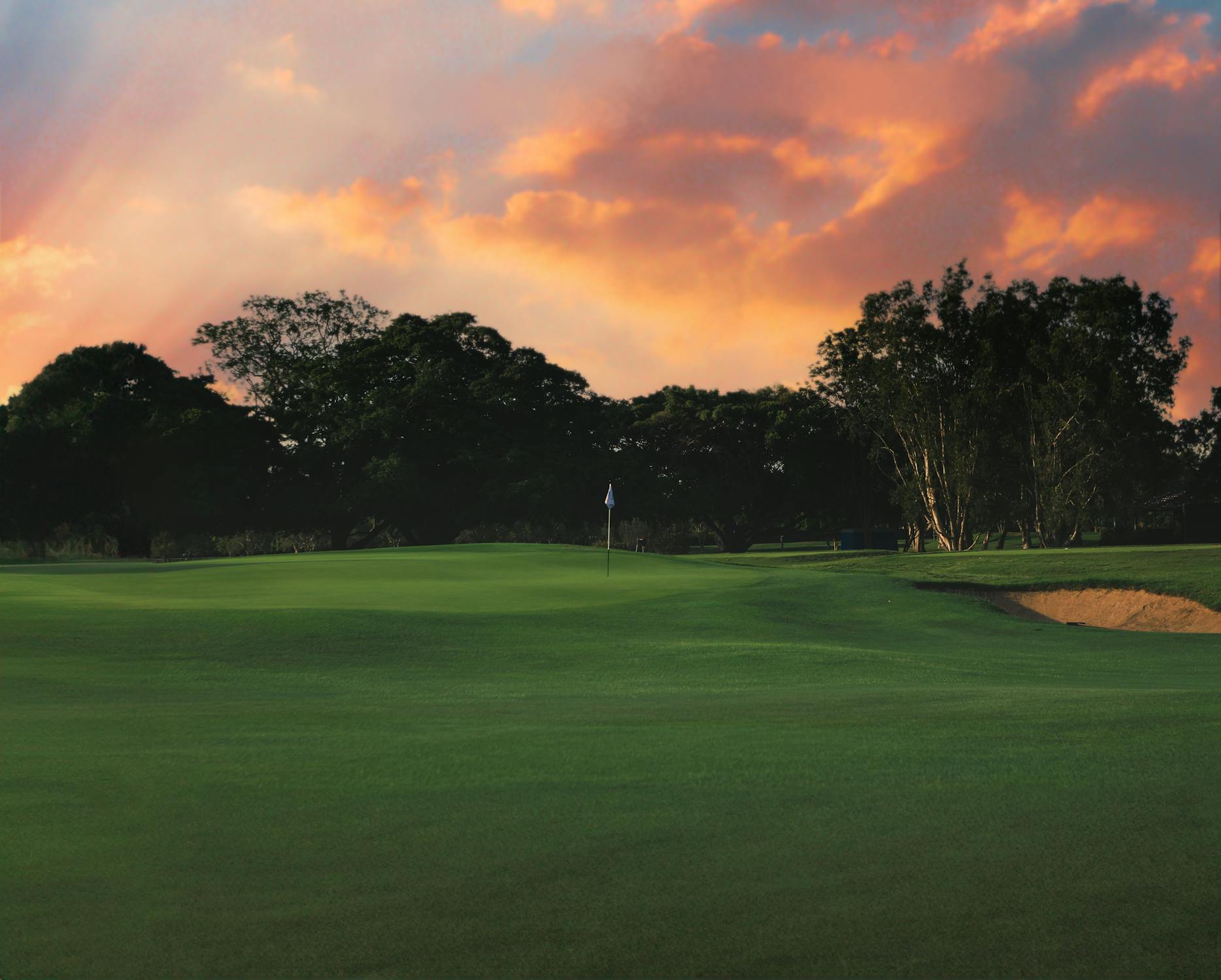 Dramatic sunset sky over a lush golf course